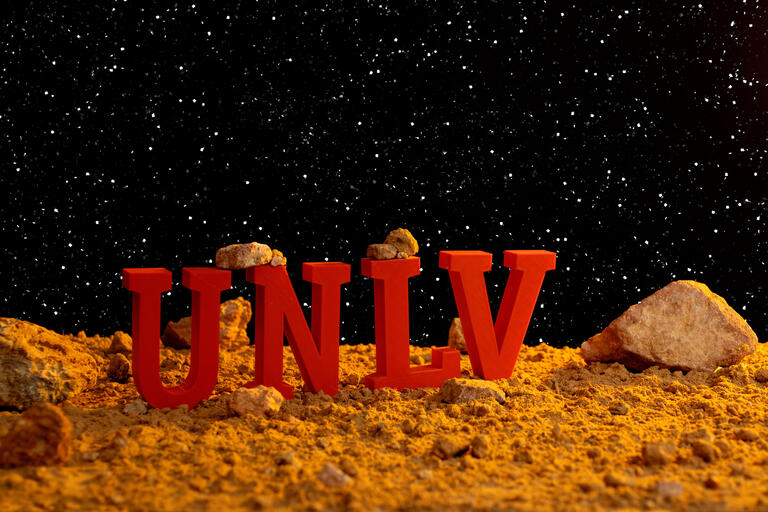 Red letters spell out &quot;UNLV&quot; in front of a space background.
