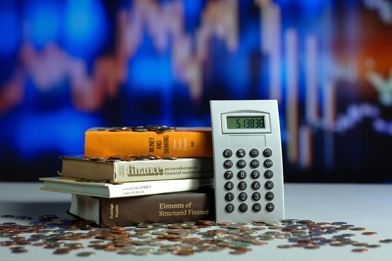 Financial literacy image featuring finance books, calculator, money