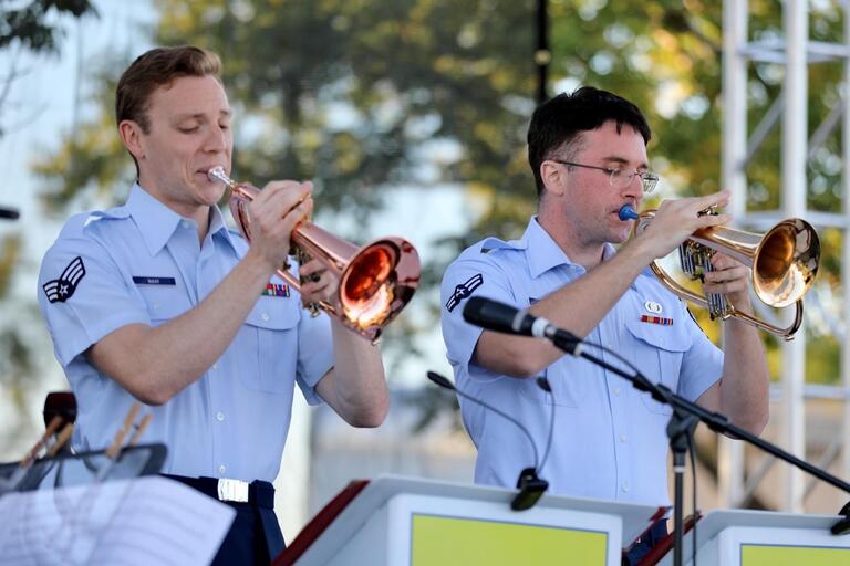 two people in uniform playing a trumpet and trombone