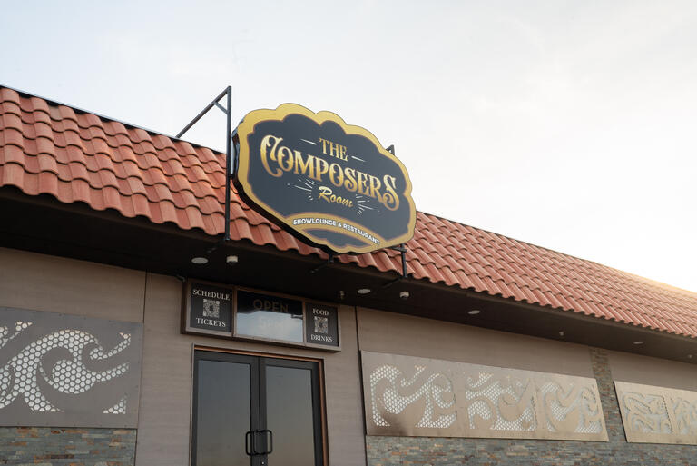 exterior of an establishment with a sign that reads the composers room