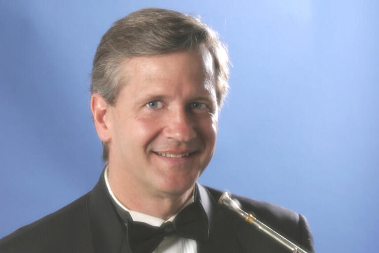 cropped photo of a smiling man in tuxedo