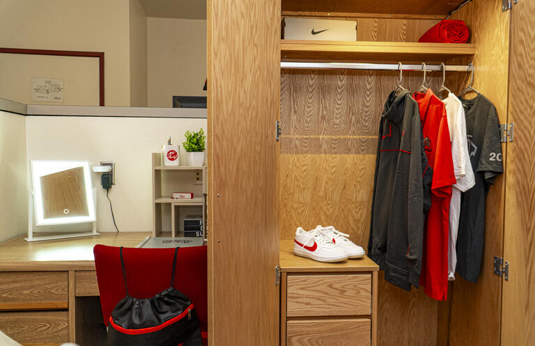 A desk next to a closet in an Upper Class Complex room