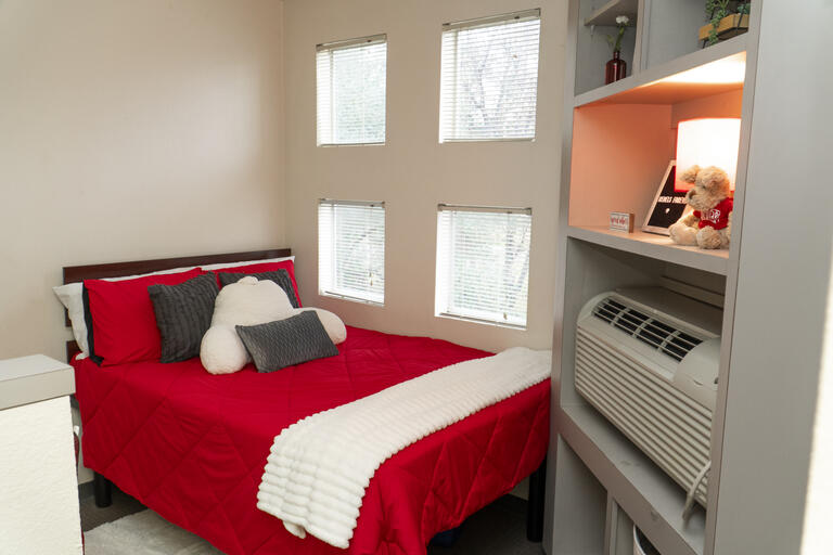 A bed next to some windows in the UCC