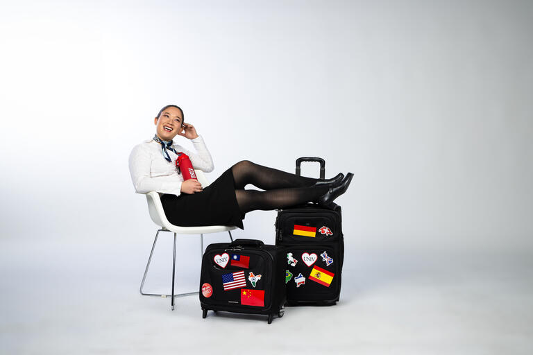 woman sitting on white seat with feet up on luggage