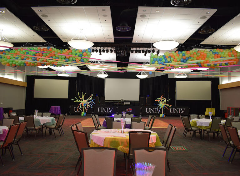 A ballroom decorated with balloons tied to the light fixture