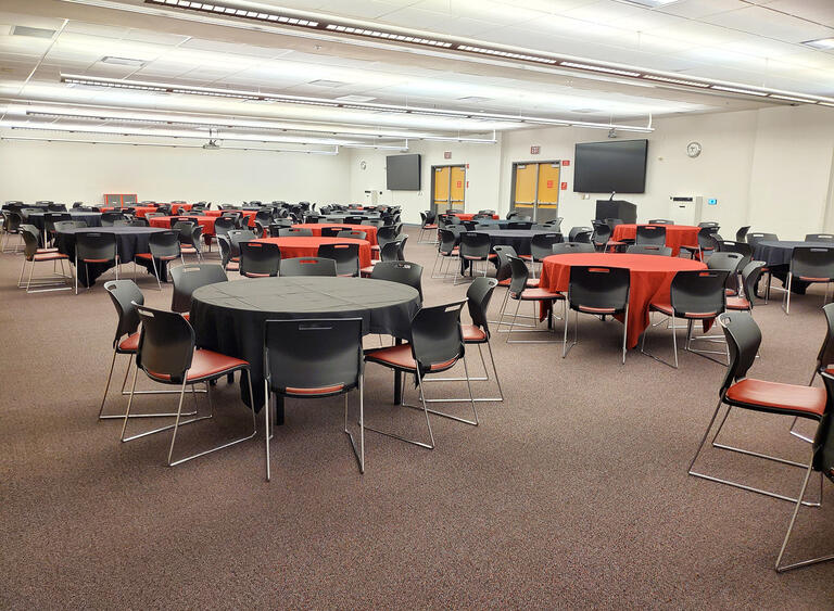 A meeting room with circular tables and chairs