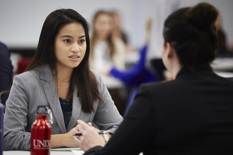 Two students sitting and talking to each other