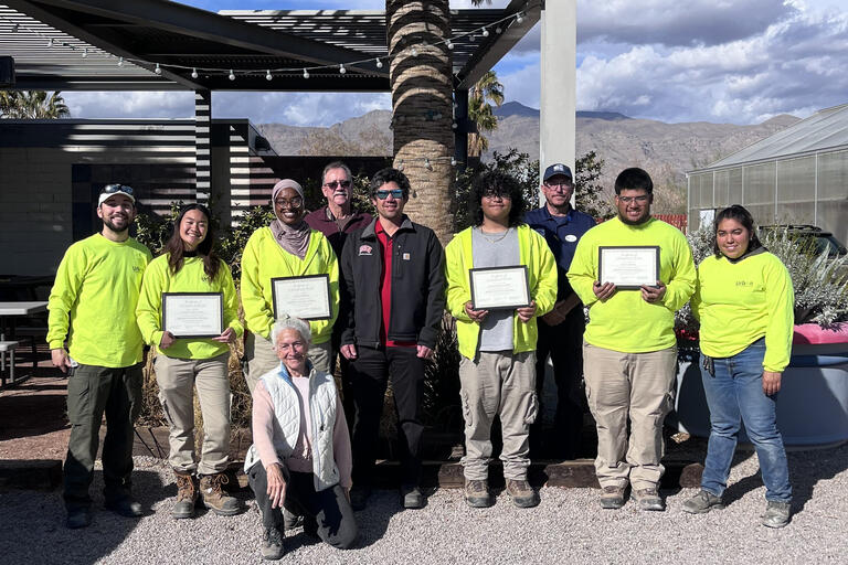 A group of people posing for a photo as each person holds a certificate.