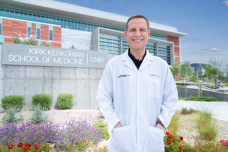 Portrait of Aron Rogers in front of the Kirk Kerkorian School of Medicine at UNLV