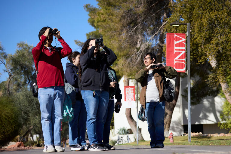 birding club members use binoculars to observe birds at UNLV