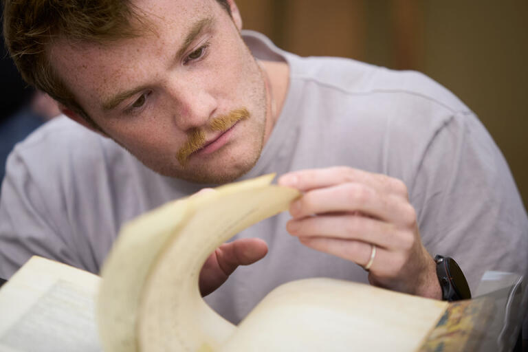 man inspecting pages of a book