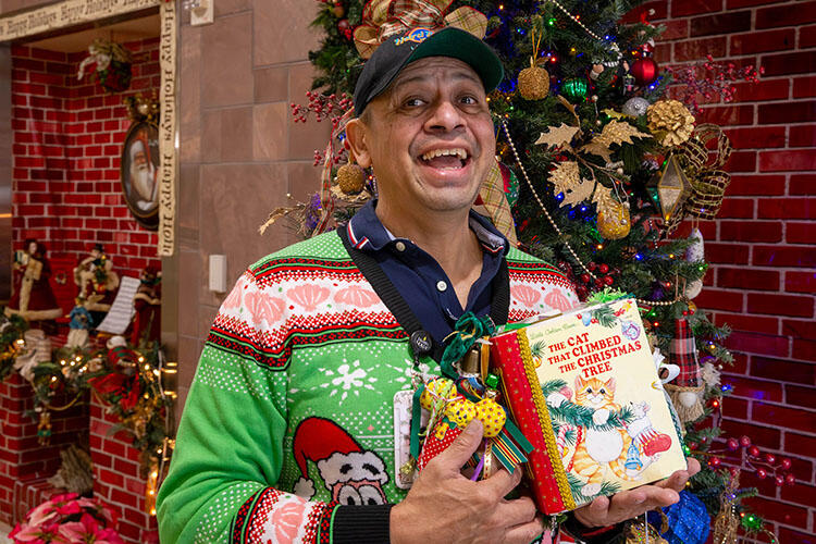 man in holiday sweater surrounded by holiday decor