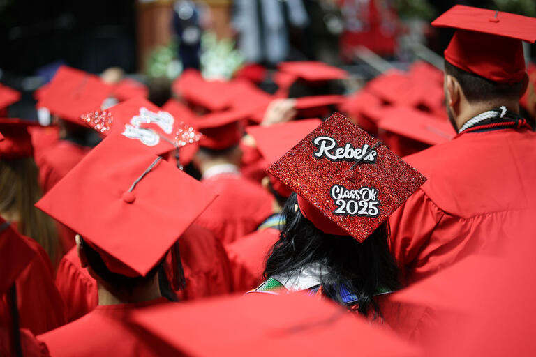 A red mortarboard with text "Rebels Class of 2025"