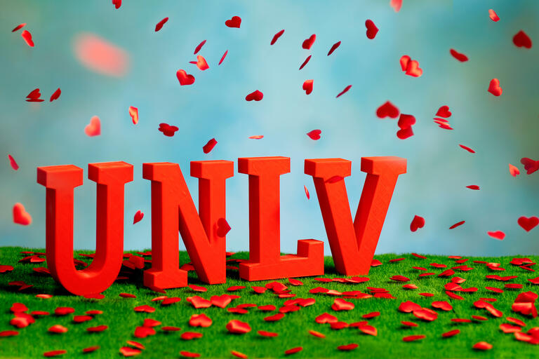 UNLV letters with red flower petals falling around it