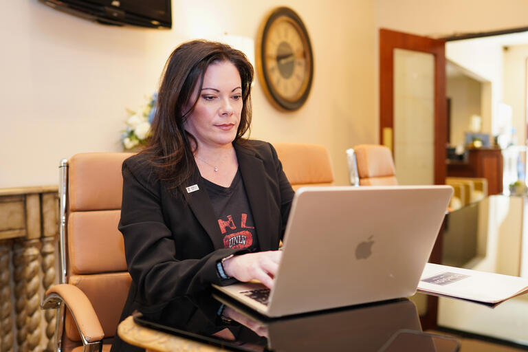 Gina Bongiovi working on a laptop