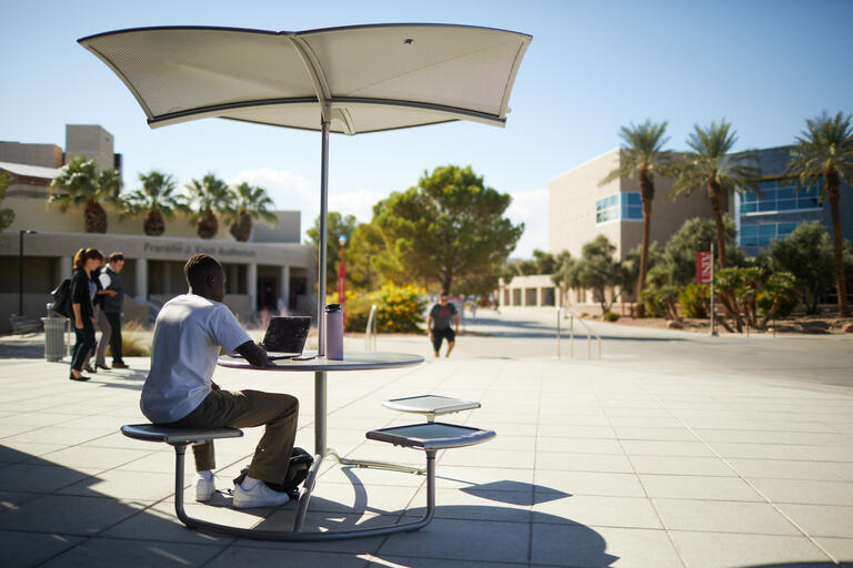 man working under umbrella in front of Student Union