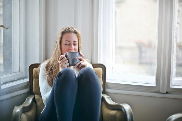 Woman drinking coffee and sitting down.