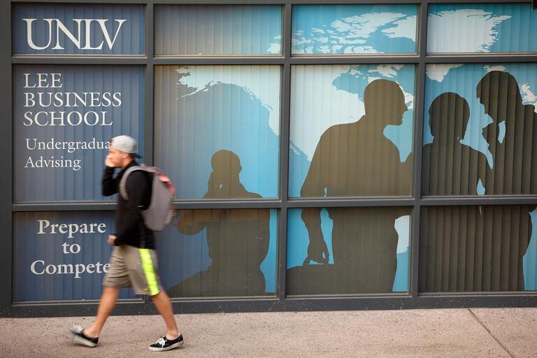 Student walking by Business Advising Center