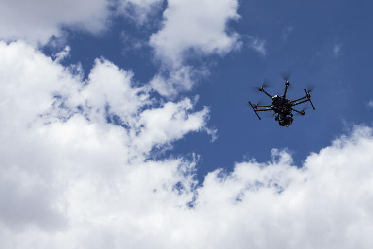 drone in air with blue sky and clouds