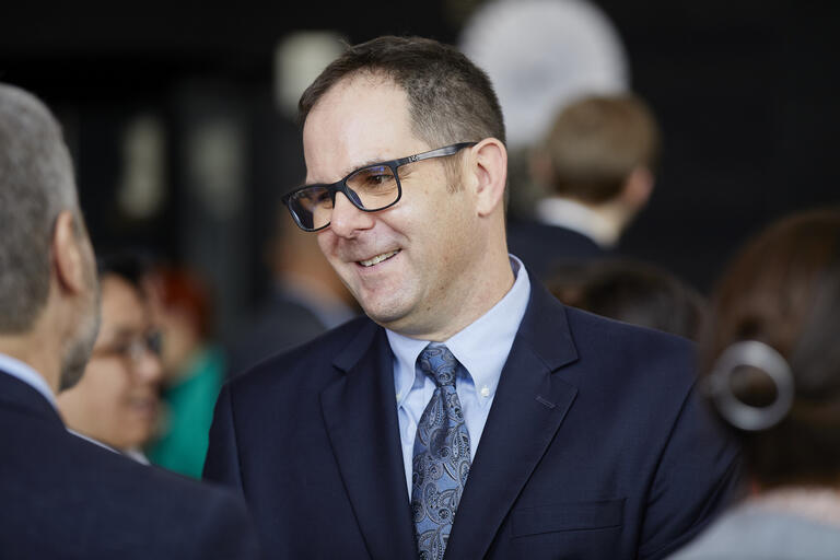 image of Dave Damore in suit during conversation at a reception