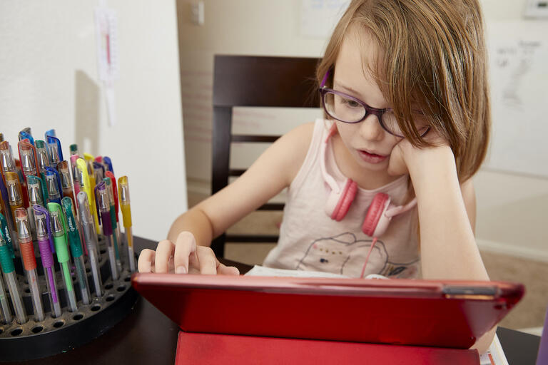 child using tablet for remote learning
