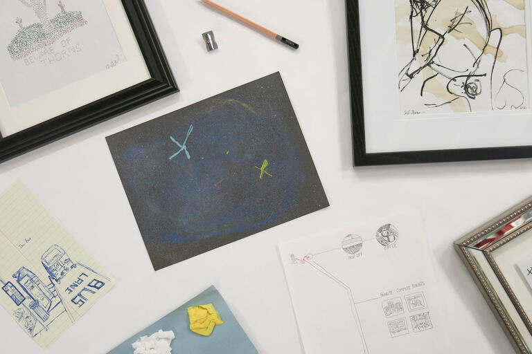A collection of various drawings, some framed, some not