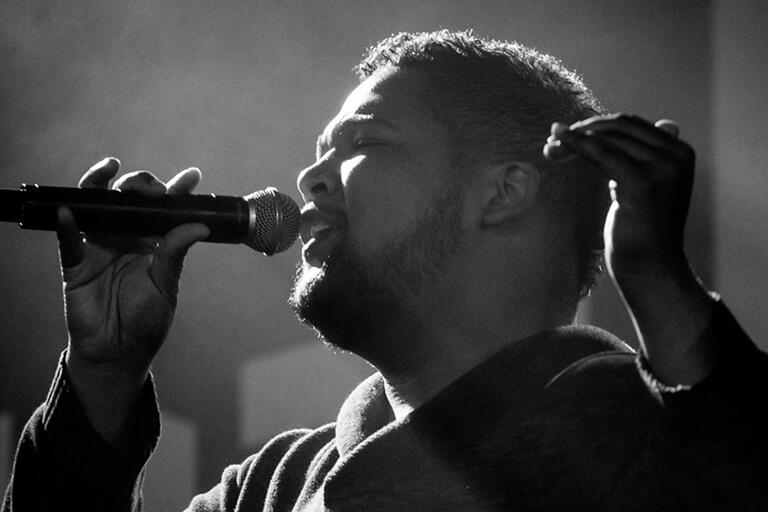 Gary Fowler holds microphone and sings