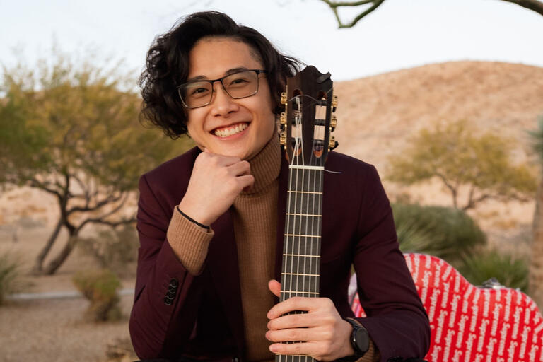 A man holds a guitar