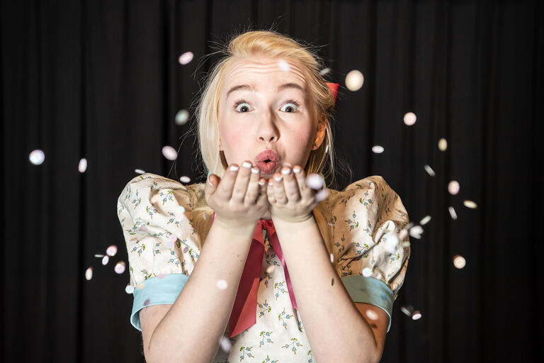 woman blowing confetti