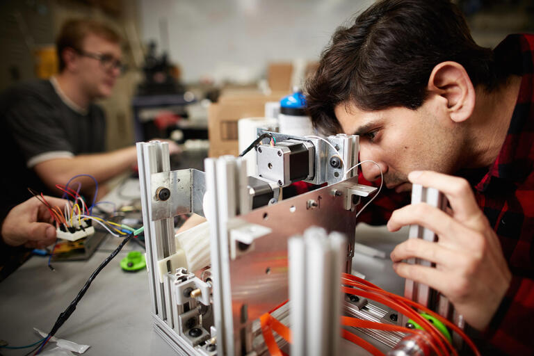 Maxim Sonsa, electrical engineering, working on his senior project, a toaster that also butters toast.
