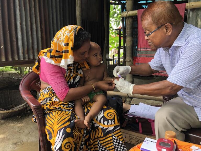 Doctor collects blood sample from a baby