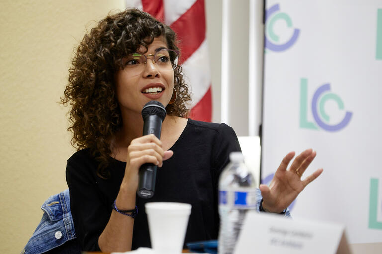 A woman speaks into a microphone