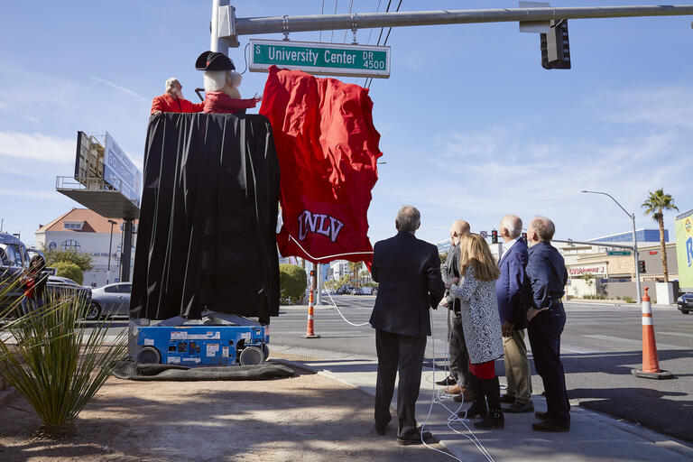 A UNLV-branded banner falls to reveal University Center Drive, formerly Swenson Street.