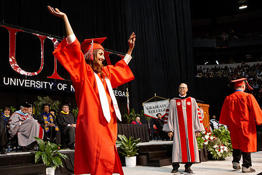 Graduate raises arms at Commencement