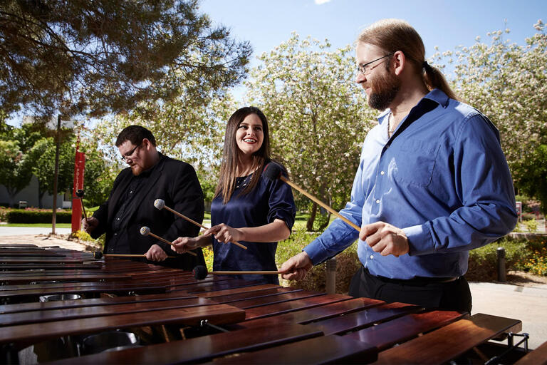 three people playing marimba