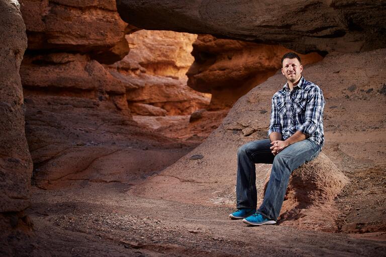 Scott Abella sits on a rock at leake mead