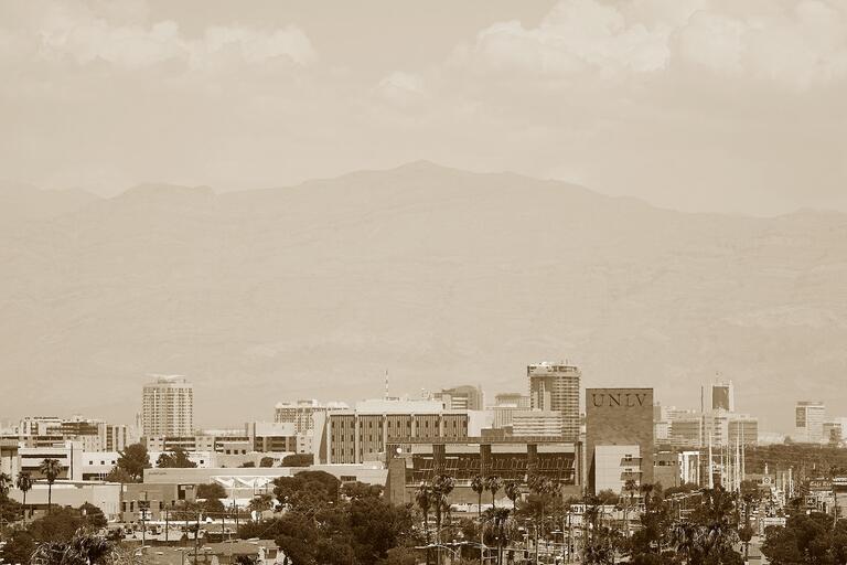Sepia tone photo of the U.N.L.V. campus with mountains and clouds in the background