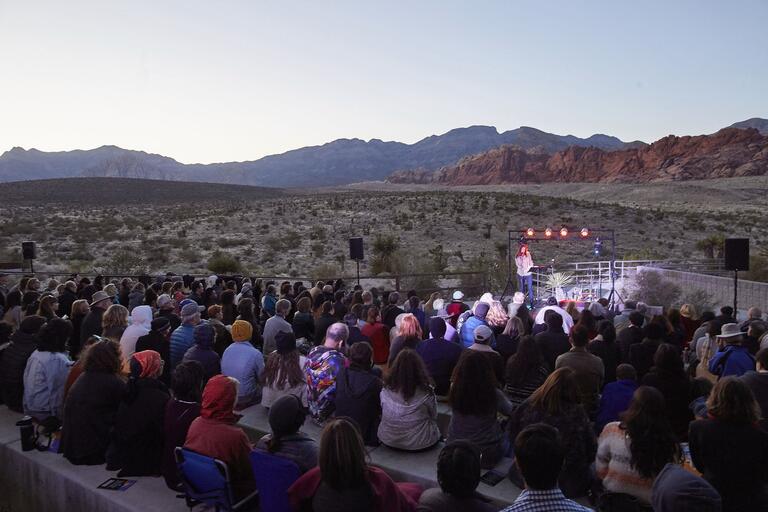 Person speaking in front of crowd at Red Rock Canyon