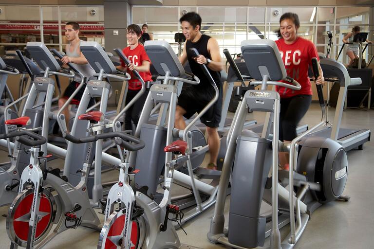 Four students use excercize bikes