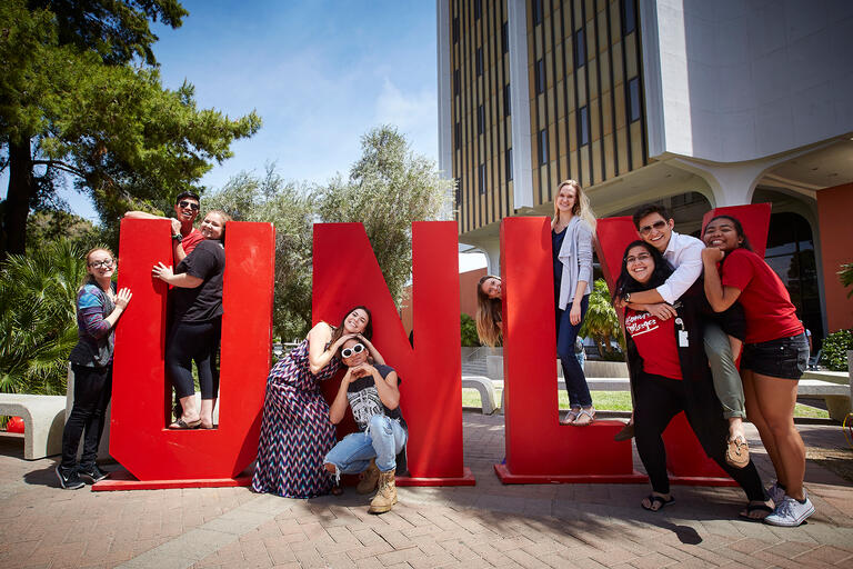 Students pose next to giant U-N-L-V letters