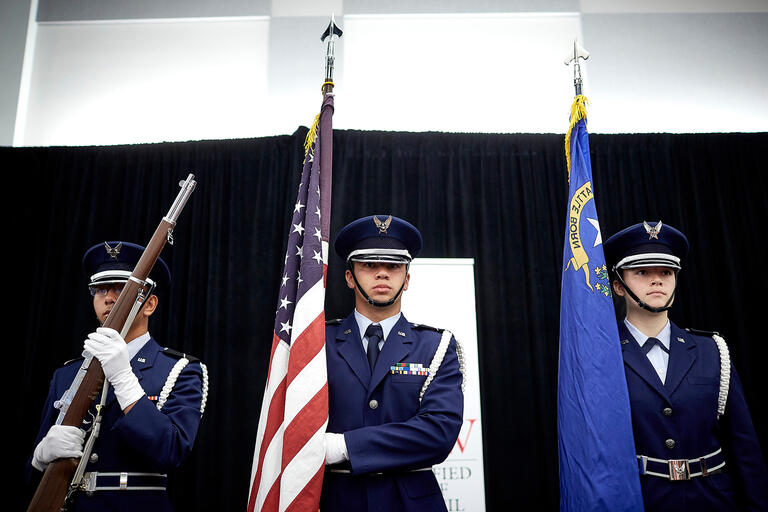 Air Force R.O.T.C. students in uniform holding flags.