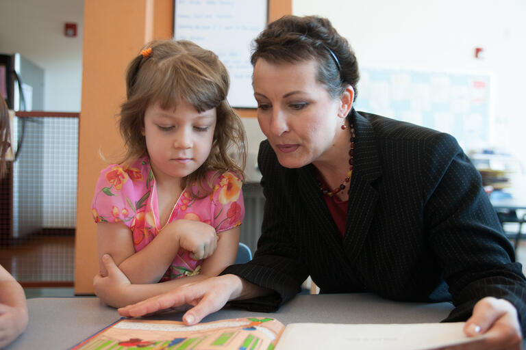 A teacher reading to an elementary school student