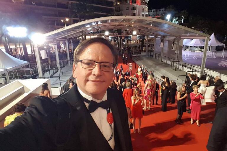 Photo of Prof. Francisco Menéndez looking into camera and a red carpet behind him