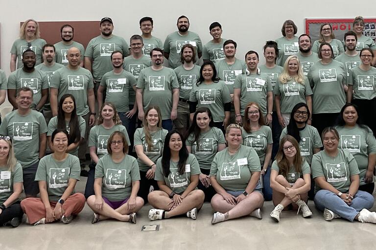 A group of teachers at a workshop all wearing the same green shirt.