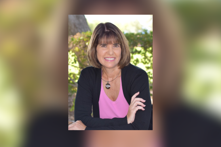 Headshot of woman smiling into the lens.