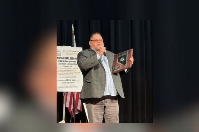 Photo of Danny Ortega winning an award and holding a microphone giving a speech