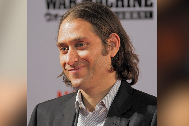 Headshot of Jeremy Kleiner, handsome man with long hair, smiling