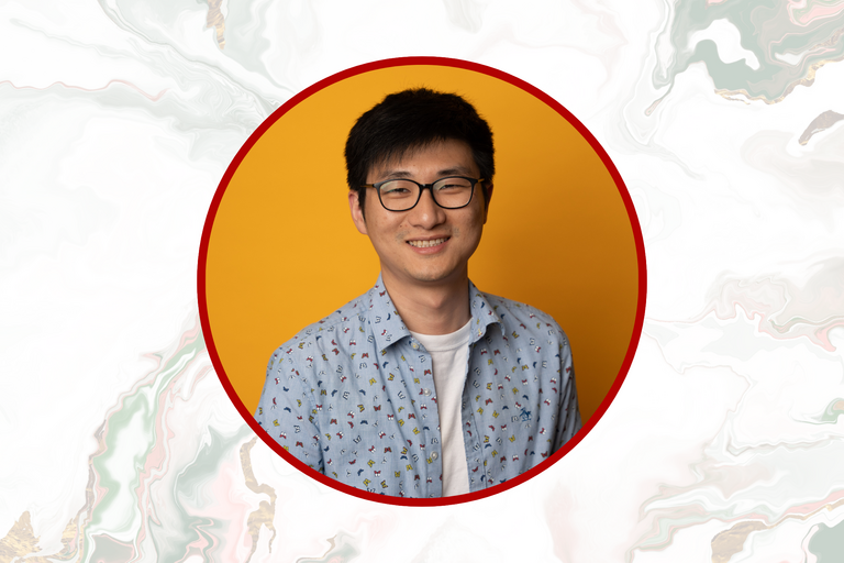 Headshot of dark haired man in glasses: Zida Wang smiling into the camera