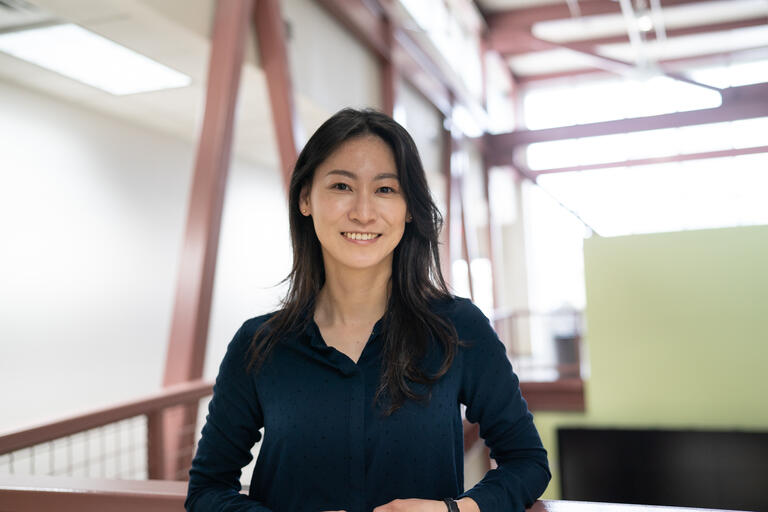 A woman, Jung-Hwa Kim, smiles into the camera