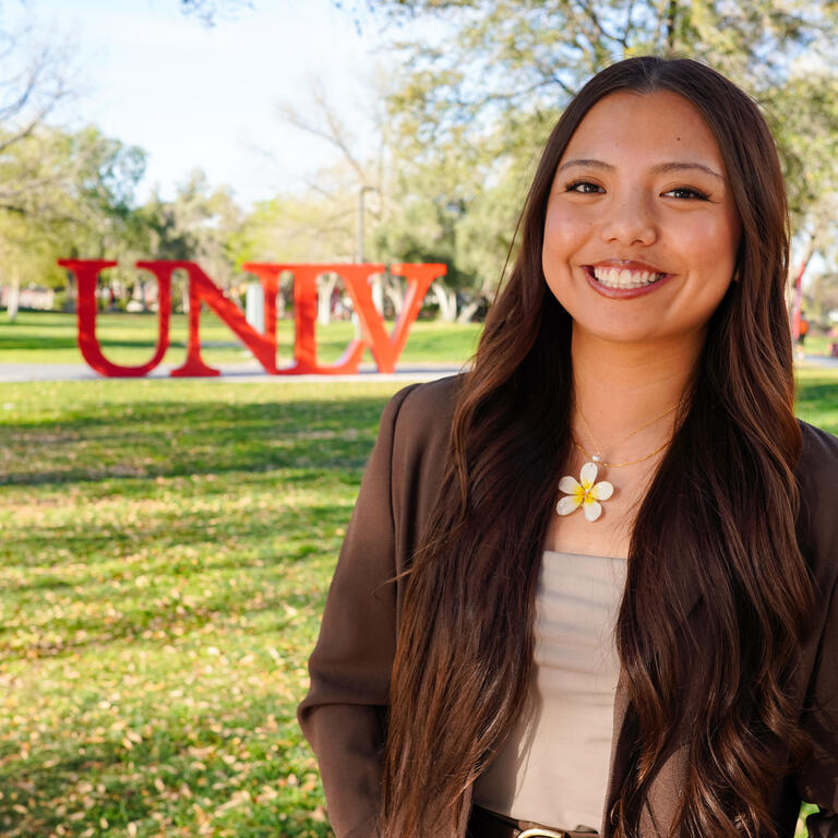Ramhae Await in front of UNLV sign on campus